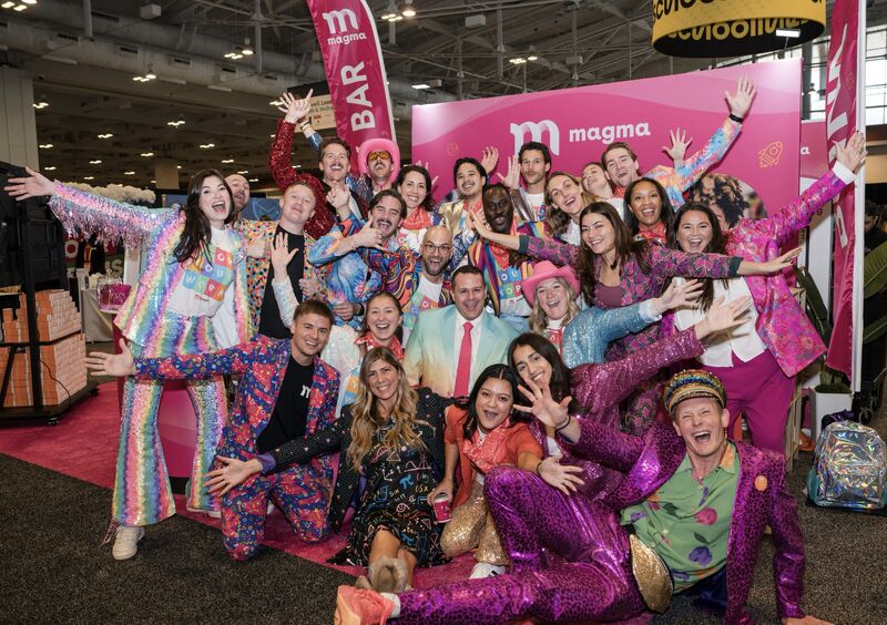 Conference booth for 7,000 attendees designed by Dixie, with a bright pink backdrop, swag table and team on site